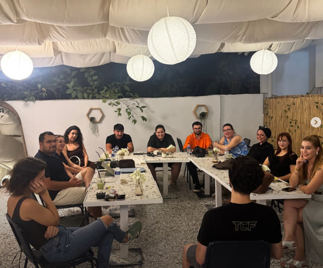 Gençlik Günü stand-up etkinliğinde bahçedeki masalara oturmuş genç bir grup gösteriyi izliyor.